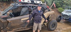 Jim Kreisman standing next to an off-road vehicle, showcasing his passion for off-roading and outdoor adventures.